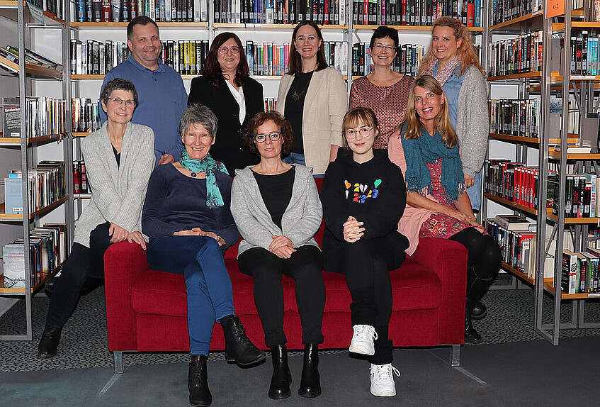 Das Büchereiteam mit Bürgermeisterin auf dem roten Sofa: Monika Müller, Barbara Link, Christine Humann, Marisa Korn, Petra Visosky (von links unten) und Dirk Stallmeister, Ute-Doris Pichler (Leiterin), Bürgermeisterin Lisa Gößwein, Pia Potkowik, Christiane Astheimer (von links oben).